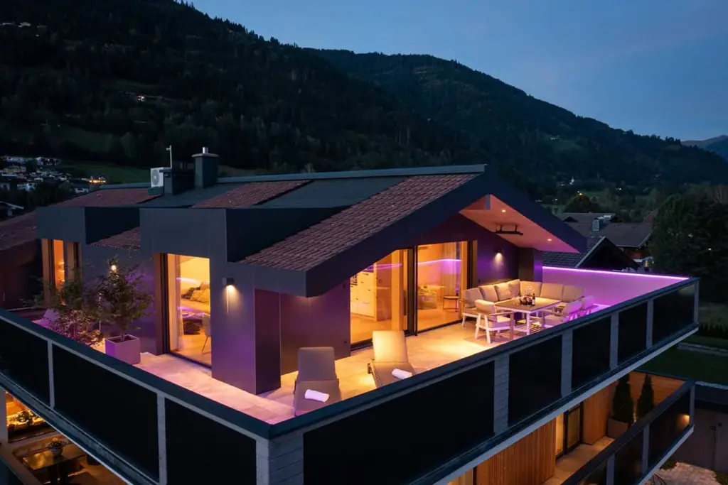 FESH LIVING penthouse in the evening: illuminated roof terrace, aerial view