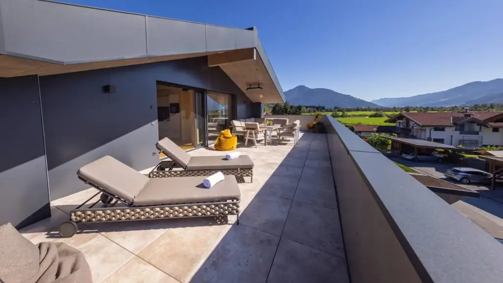 Penthouse terrace with lounge furniture, sun loungers and glacier view