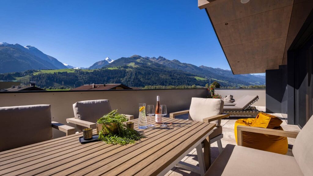 Penthouse roof terrace with lounge furniture and view of the Kitzsteinhorn glacier