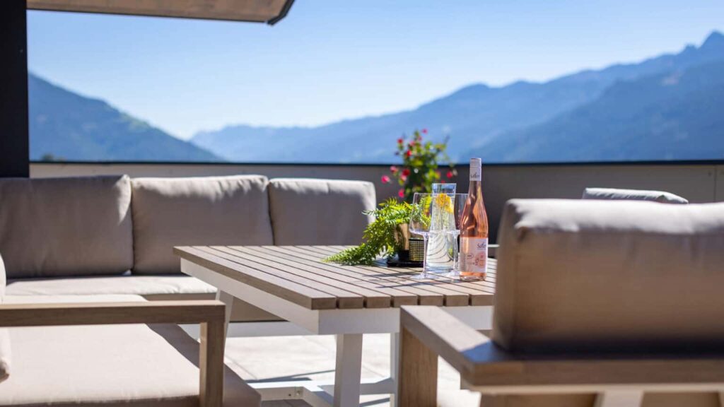 Penthouse terrace with lounge furniture and mountain views towards the Kitzsteinhorn